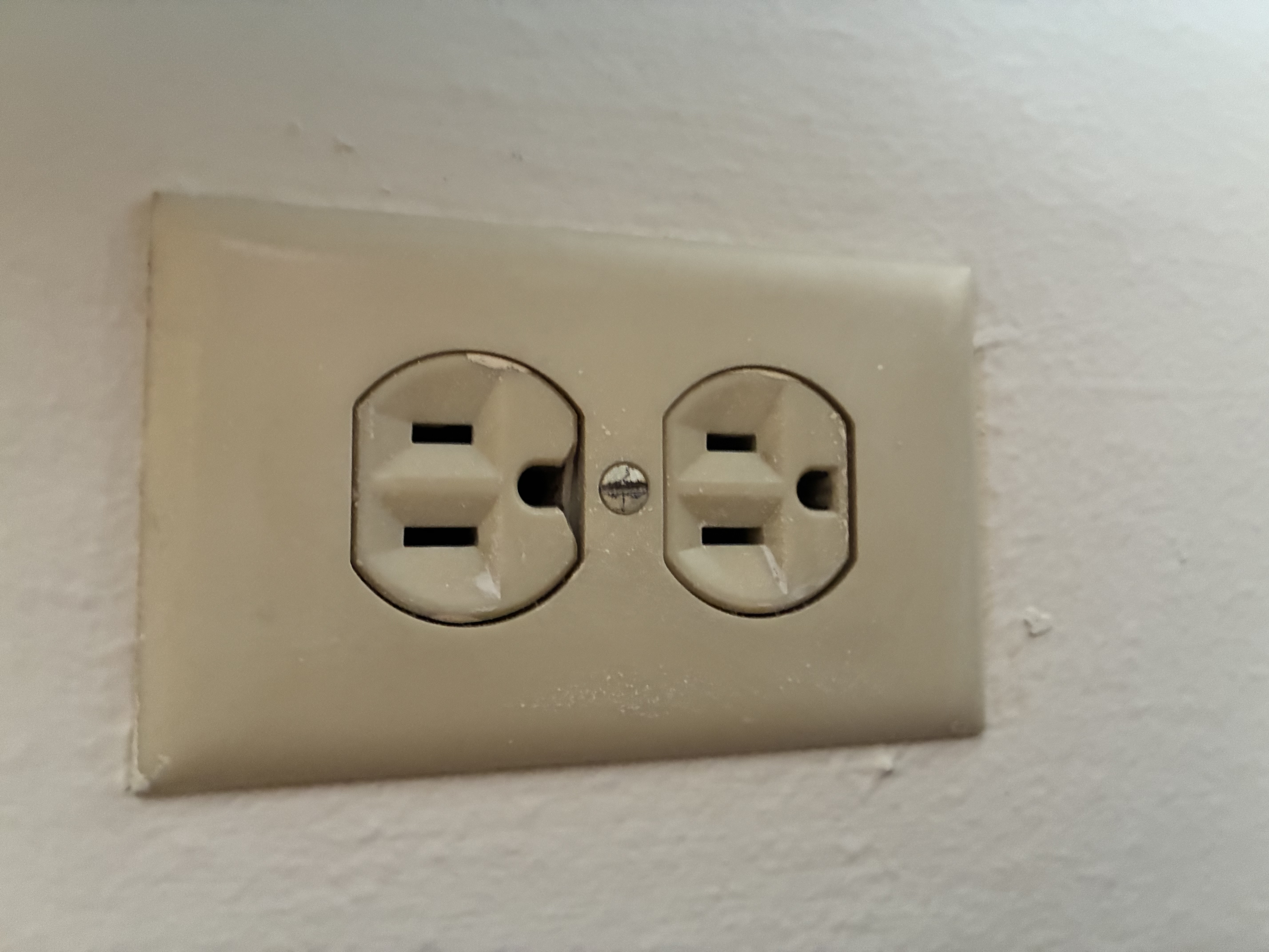 Older discolored standard outlet before replacement